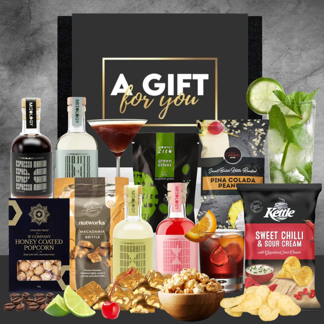 Gift basket with drinks, snacks, and a cocktail setup on a gray background