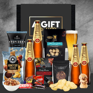 Gift set with beer, snacks, and candies on a gray background