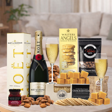 Gourmet gift set with Moët & Chandon champagne, snacks, and crackers on a table.