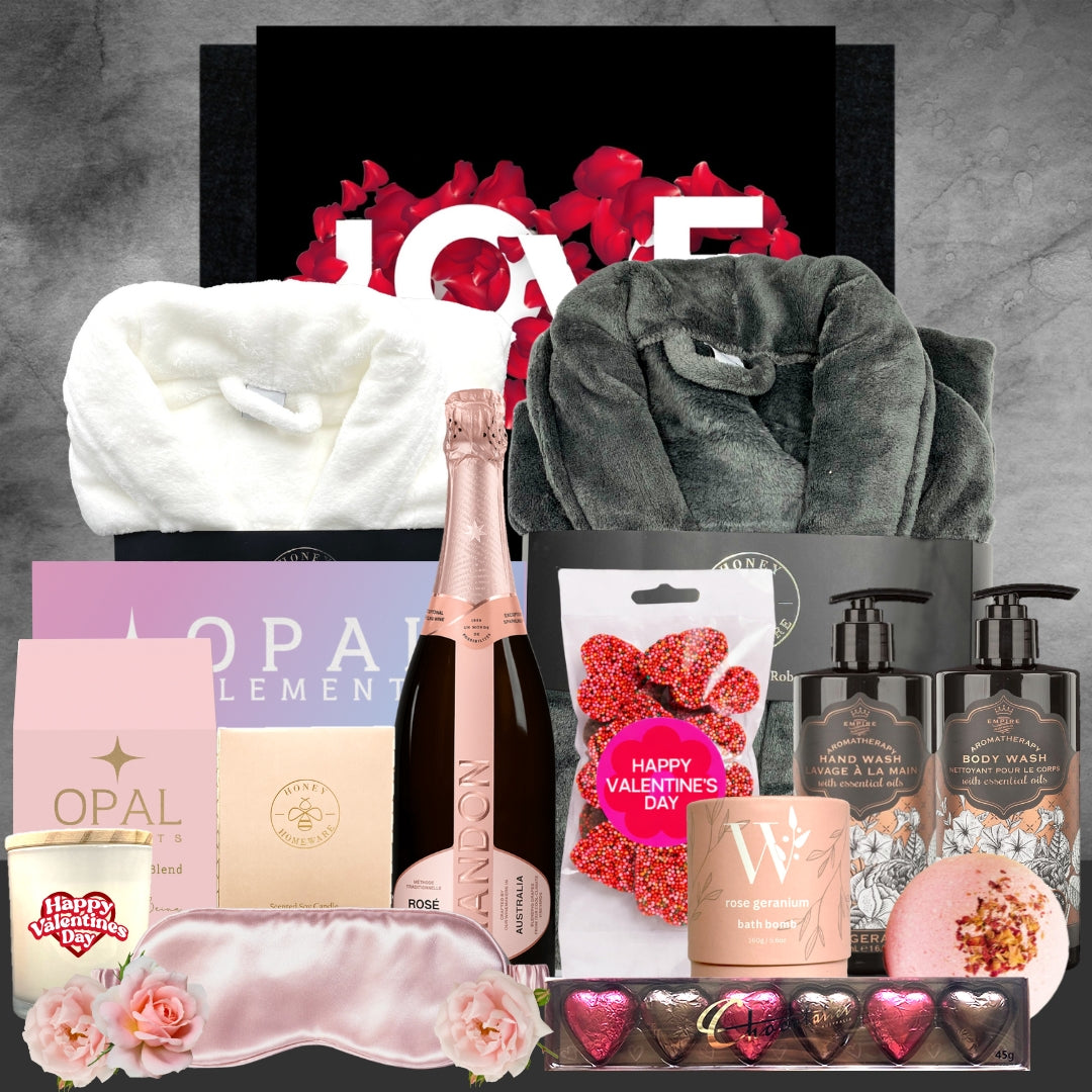 Valentine's Day gift basket with champagne, bath products, and other items on a gray background.