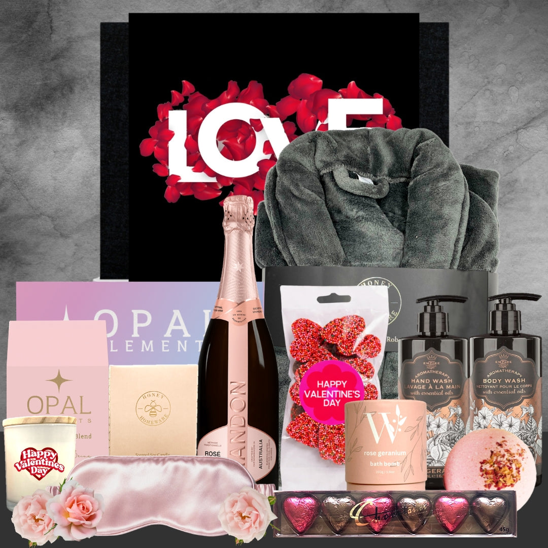 Valentine's Day gift basket with champagne, bath products, and other items on a gray background.