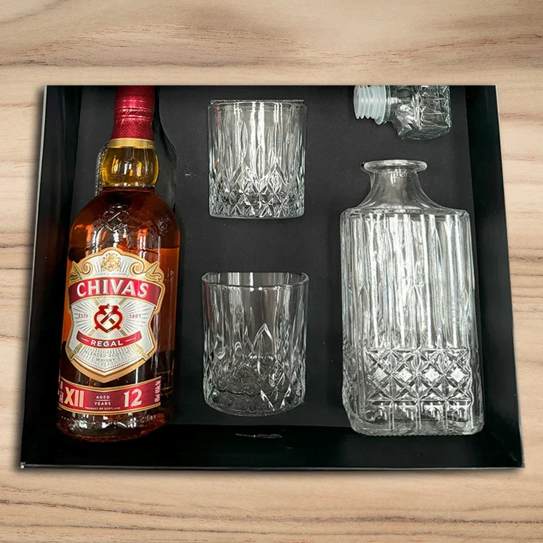 Chivas Regal bottle with two glasses and a decanter on a black tray