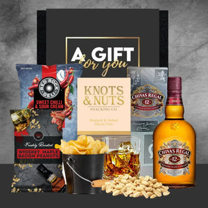 Gift set with Chivas Regal whiskey, snacks, and a 'Gift for You' card on a gray background.