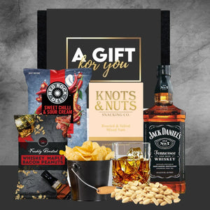 Gift set with snacks, a bottle of Jack Daniel's whiskey, and a 'Gift for You' card on a gray background.