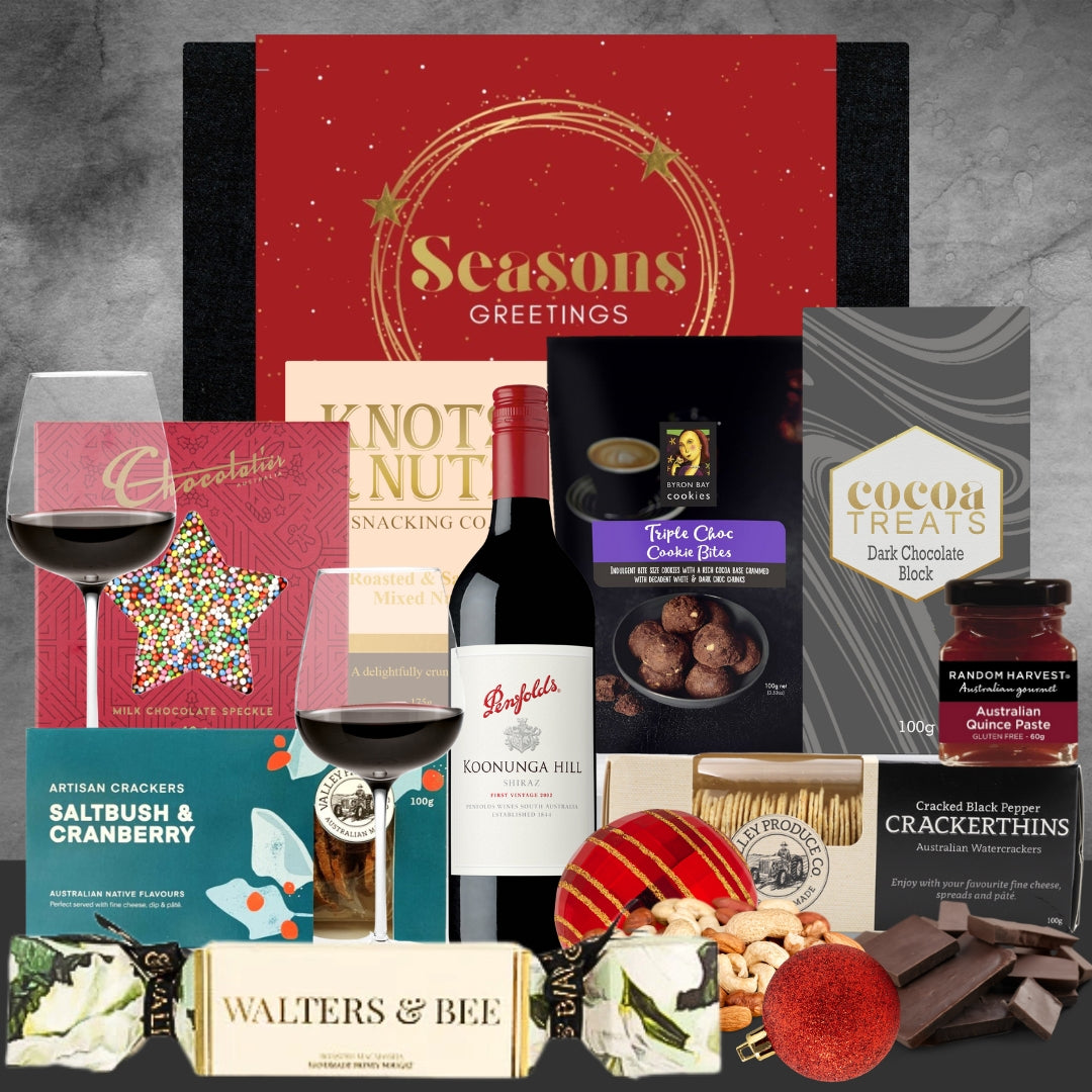 Christmas Assorted holiday gift items including wine, chocolates, and treats on a gray background.