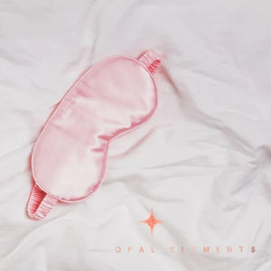 Pink sleep mask on a white fabric background with 'Opal Elements' branding.
