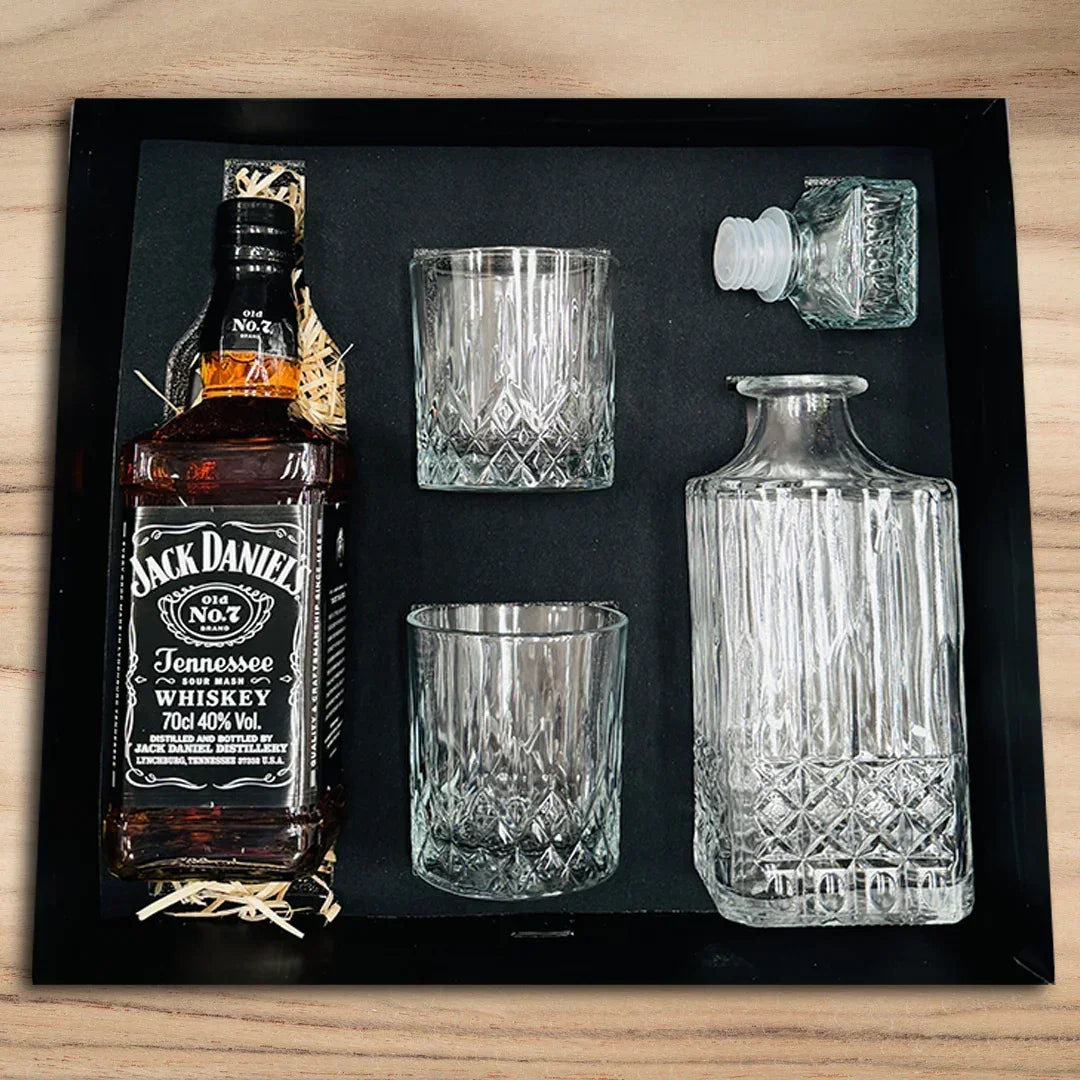 Jack Daniel's whiskey bottle with glasses and a decanter on a black tray.