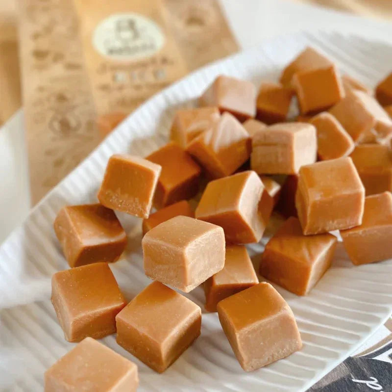 Caramel squares on a white plate with a blurred background