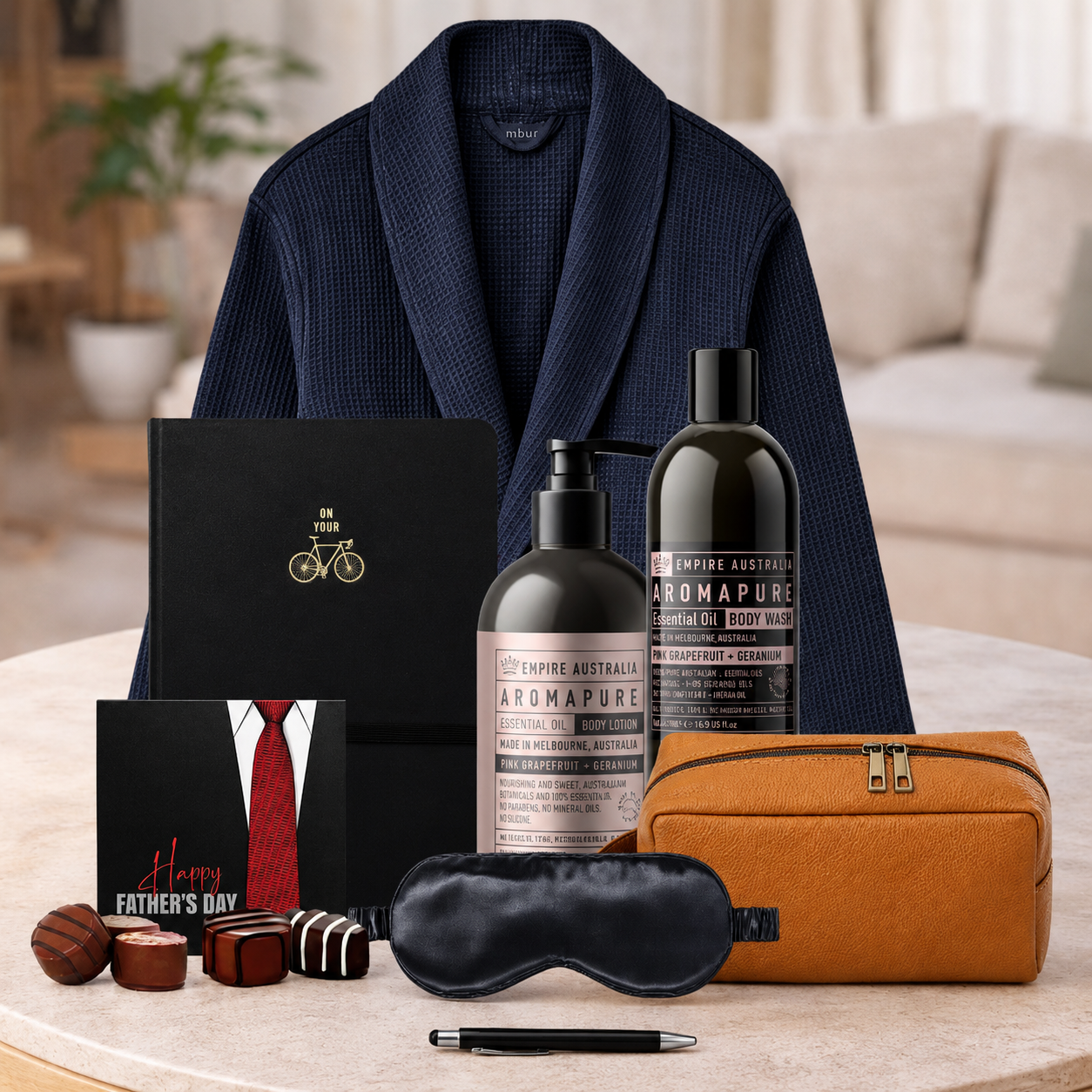Self care gift hamper for Dad featuring luxury bath robe, shampoo, body wash, toiletry bag, notebook and Father's Day chocolates.